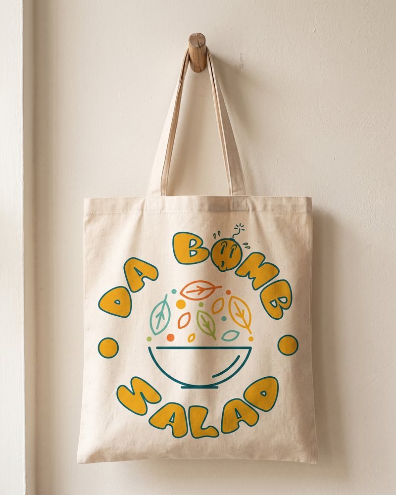 Mockup of the Da Bomb Salad logo screen-printed on a canvas tote bag