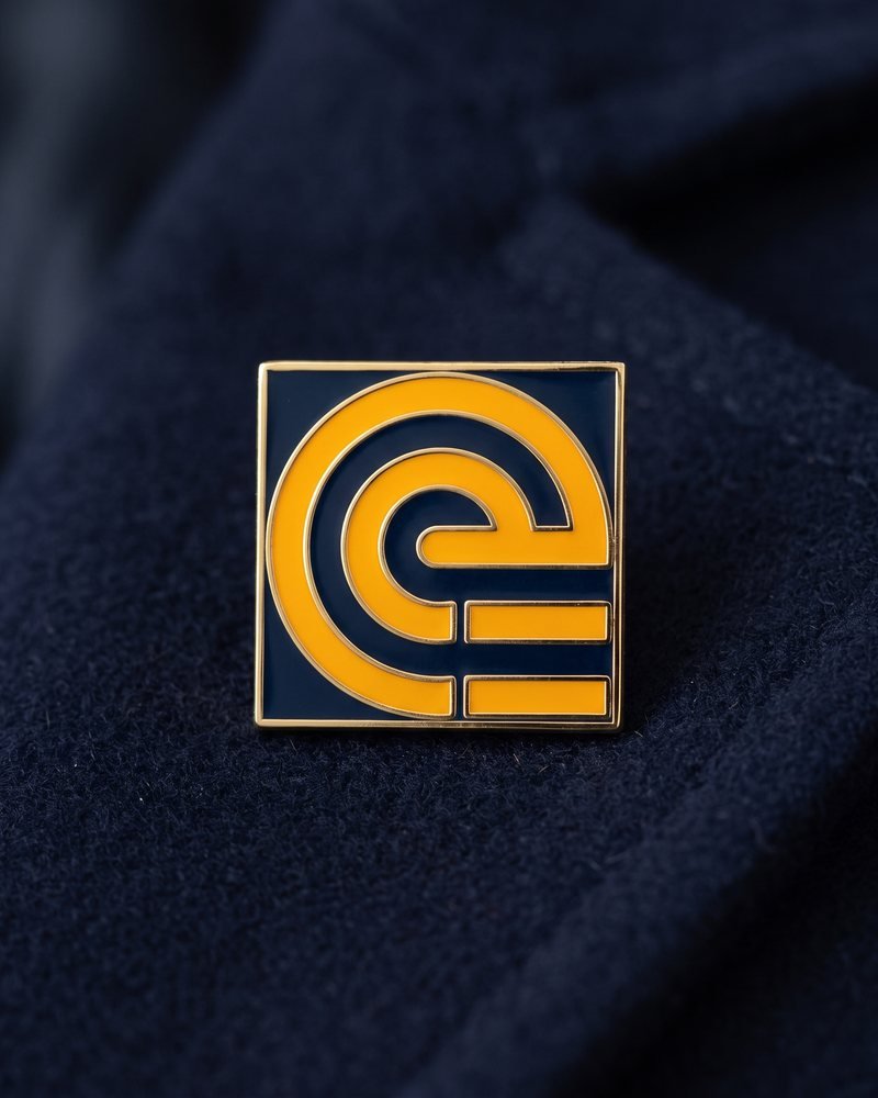 Mockup of the SignalStack symbol as an amber enamel pin